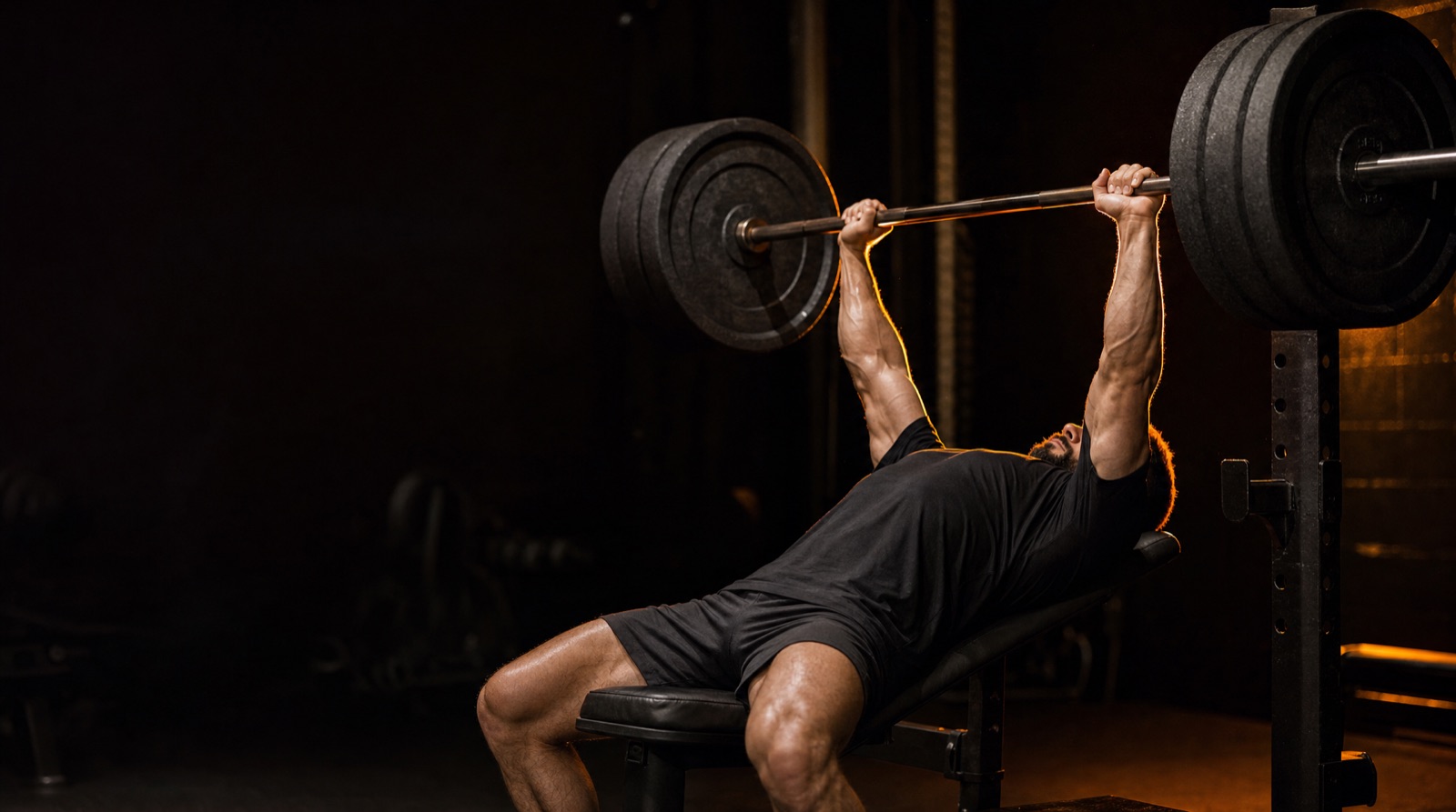 Lifter locking out 405 lbs on the bench, arms stacked over the shoulders
